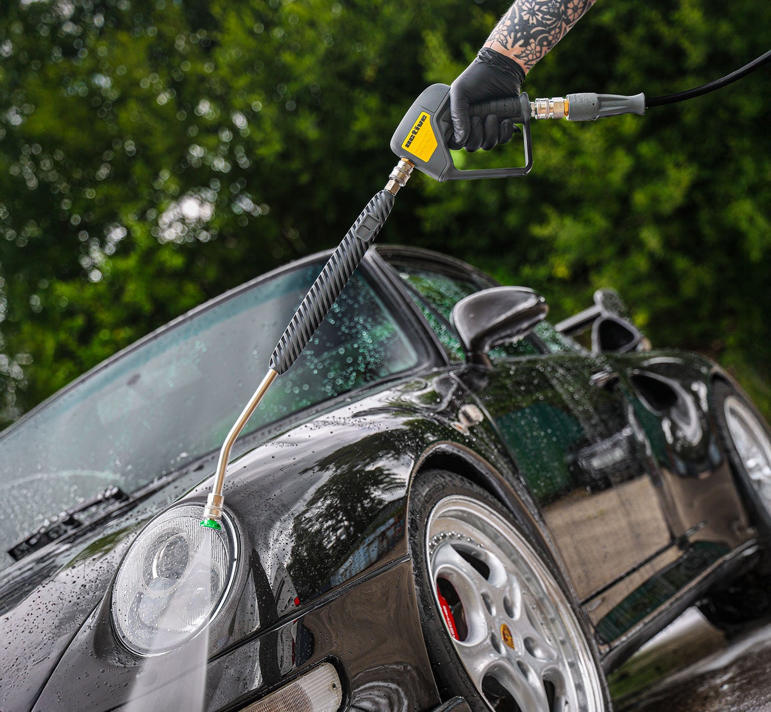 Person washing a black car with a  Active™ Premium Pressure Washer 20° Lance