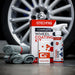 GTechniq car care products including a spray bottle, towels, and packaging in front of a car wheel.