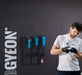 Man preparing for a workout with gloves on, standing against a dark background with 'GYEON' branding.