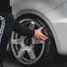 Person using a Gyeon Tire Dressing Applicator on a car tire