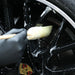 Person cleaning a Sponge Guru Oval Wheel Brush