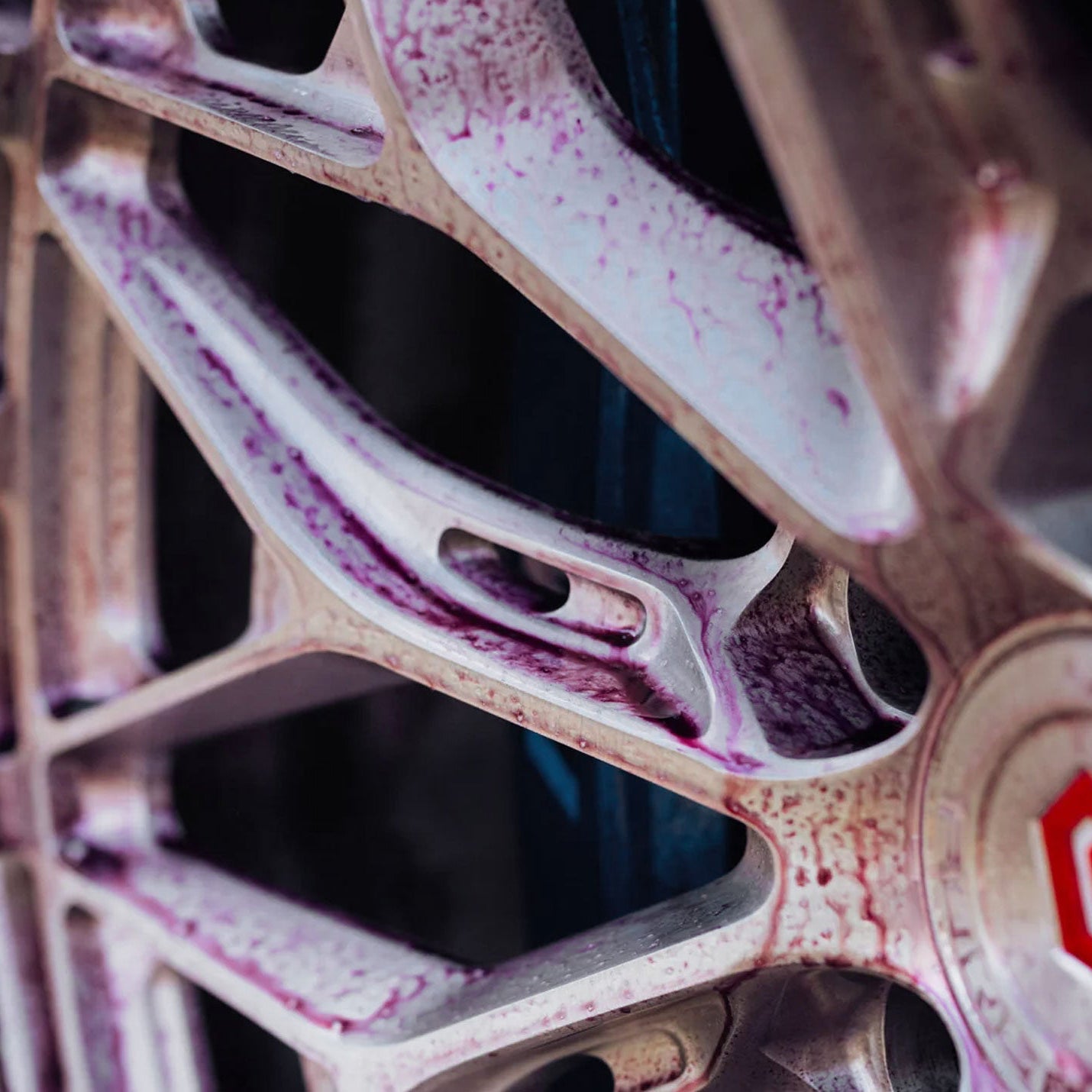 Close-up of a car wheel with a red logo on a blurred background
