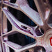Close-up of a car wheel with a red logo on a blurred background