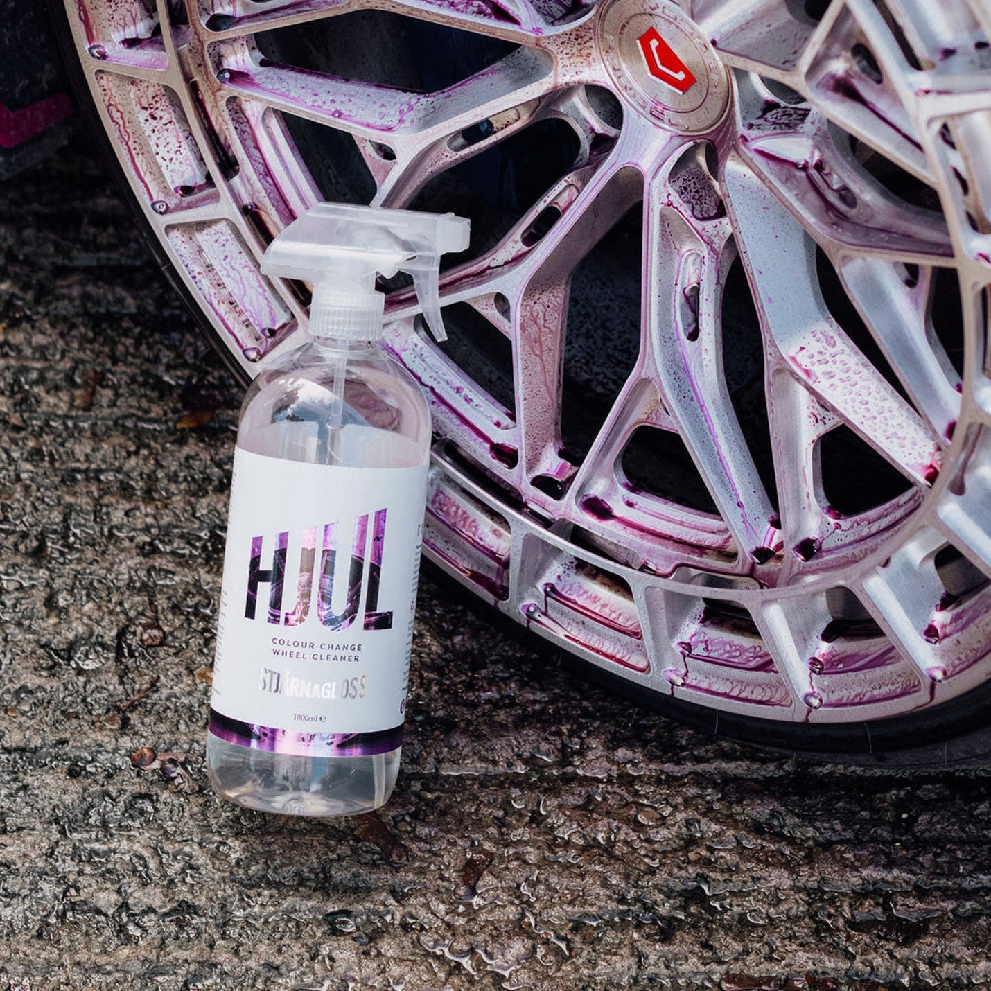 Bottle of Stjarnagloss Hjul car cleaning product next to a car wheel on a concrete surface