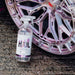 Bottle of Stjarnagloss Hjul car cleaning product next to a car wheel on a concrete surface