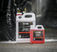 Two bottles of Valet Pro Citrus Pre Wash on a car wash platform with a blurred car tire in the background.