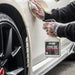 Person cleaning a car door with a bottle of Valet Pro Citrus Tar & Glue Remover.